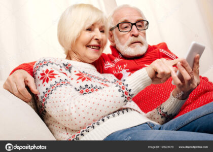 närståendepenning (Ett äldre par som sitter bredvid varandra med en läsplatta mellan sig)e